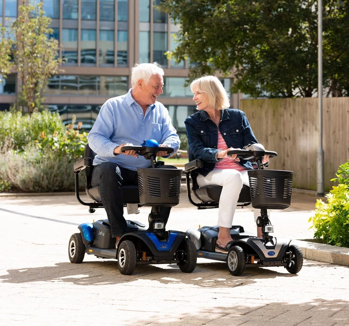 A man and a woman on their TGA mobility scooters